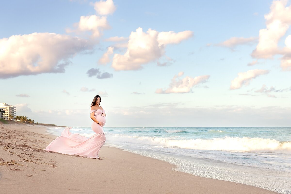 pink dress on maternity portraits by the ocean