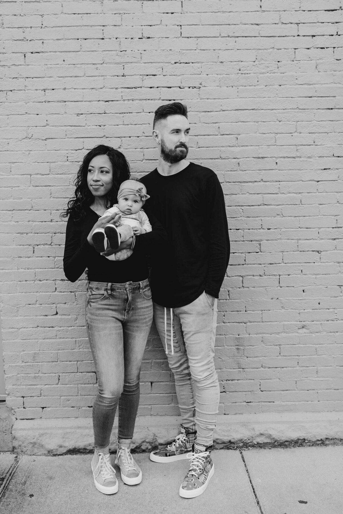 Black and white photo of a family standing together outdoors, sharing a quiet moment.