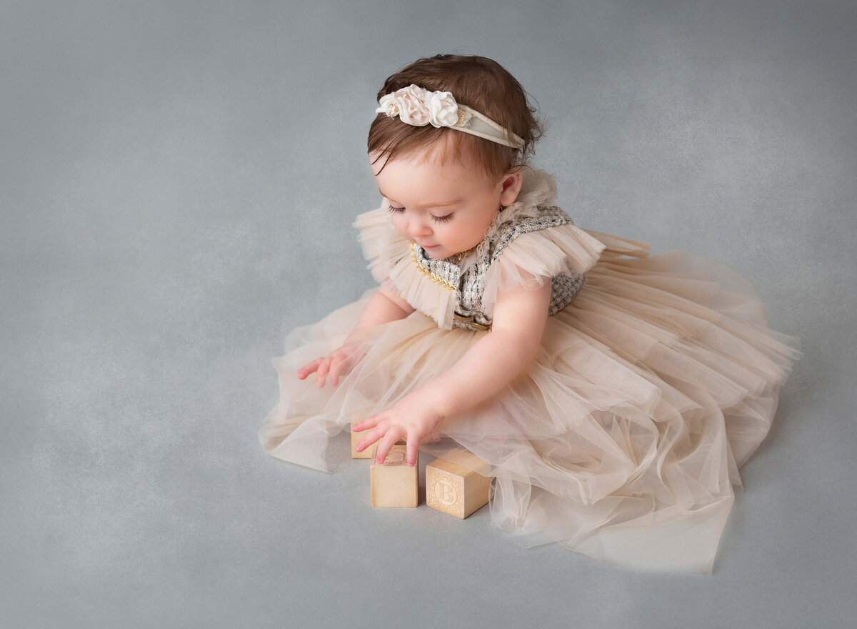 Brooklyn, NY baby photography a girl playing with wooden locks at her 1st birthday photoshoot