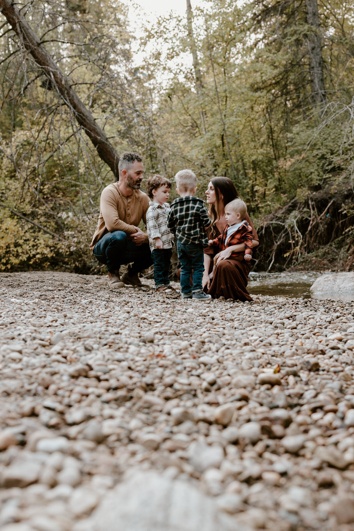 Family crouching by a stream