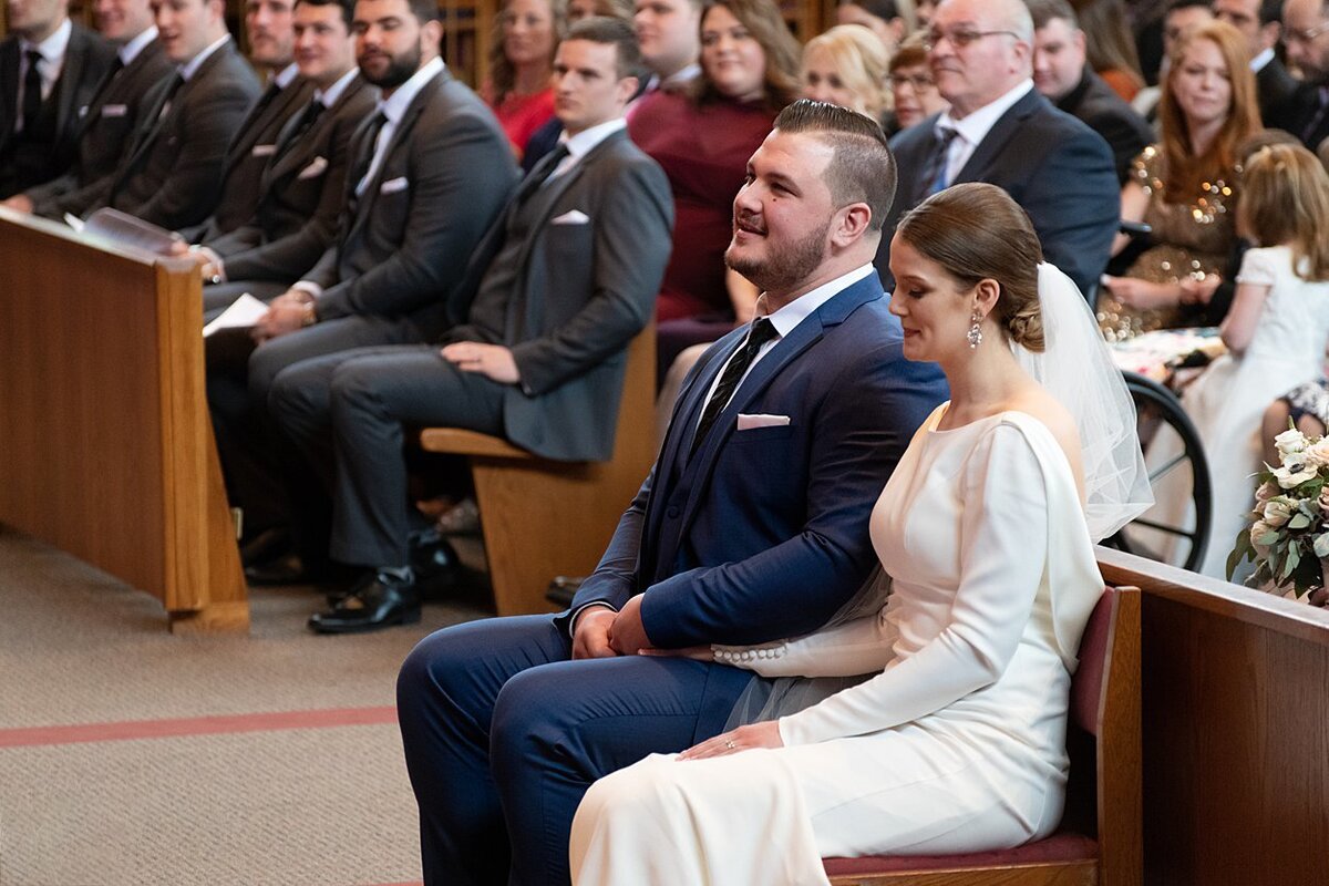 NFL free agent Groom and Bride sit during wedding ceremony at St. Bonaventure Church in Pittsburgh, PA