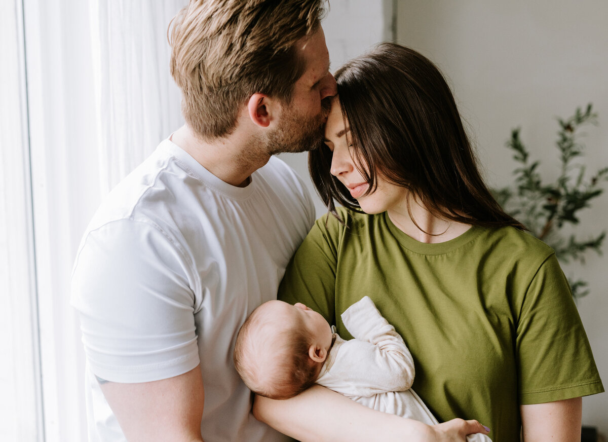 A mother and father share a moment with their newborn at Studio Atelier