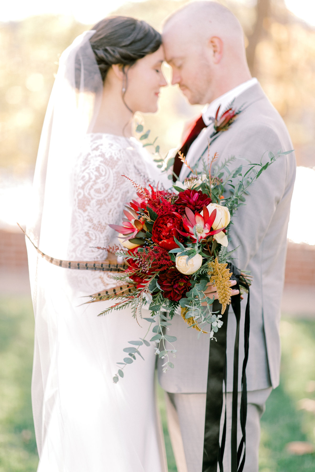 bride and groom with burgundy and orange bouquet