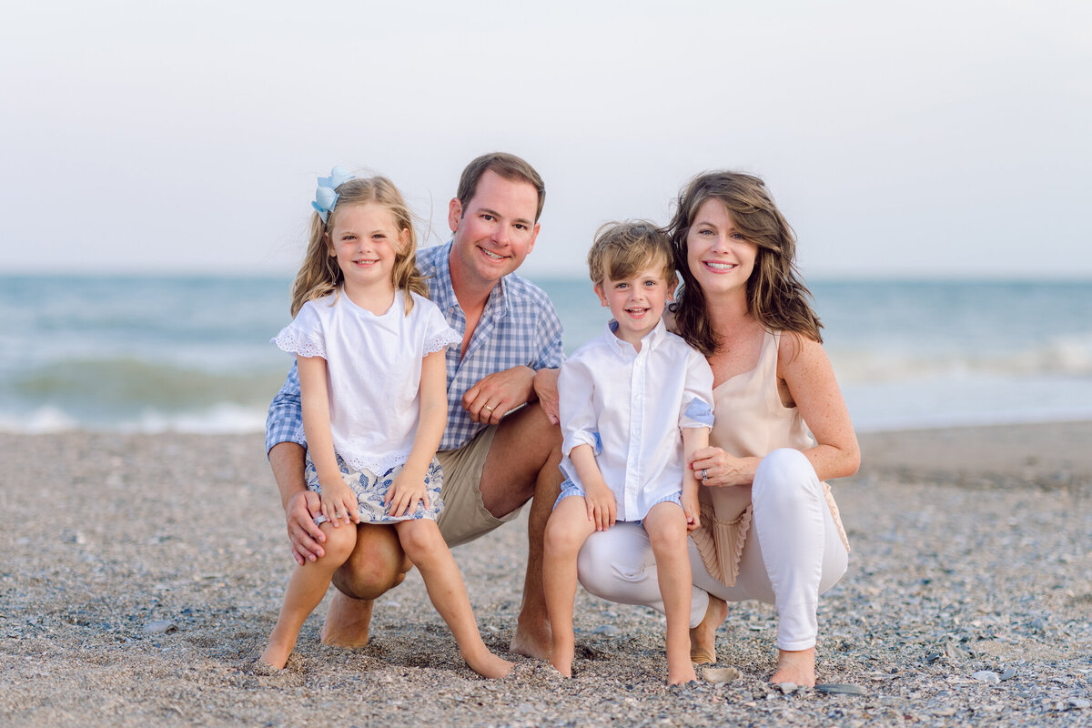 Mom and dad holding hands with their baby girl during a portrait session in Myrtle Beach, SC