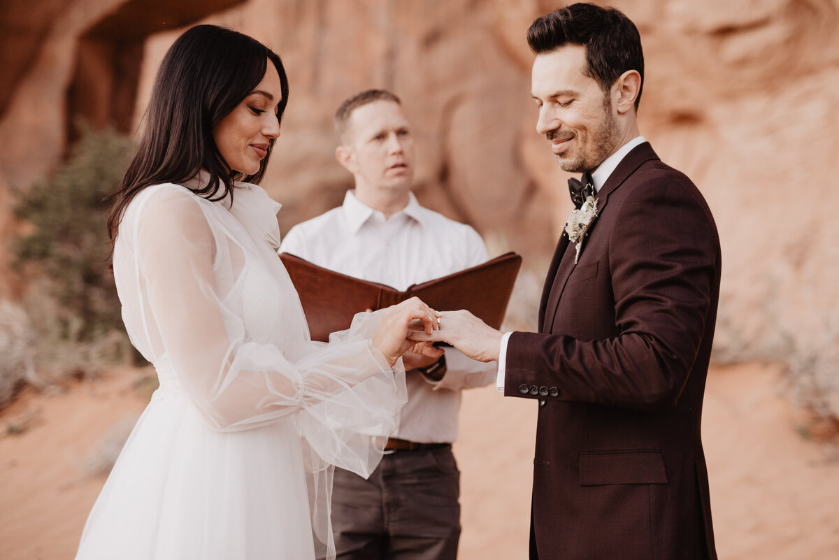 Utah elopement photographer captures bride and groom holding hands during vow ceremony