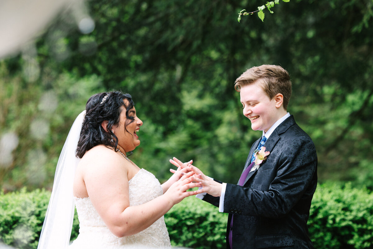 Brides holding hands and smiling at the hands