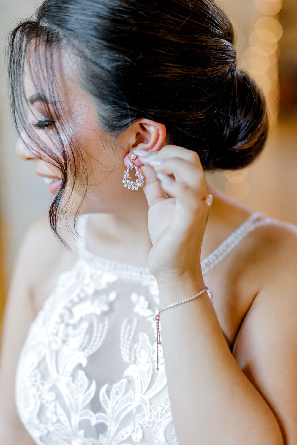 Bride putting on earrings