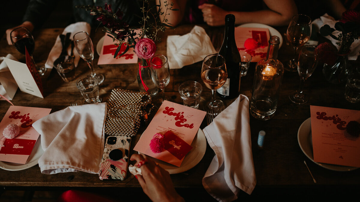 Flat lay photo of pink wedding stationery on a concrete floor