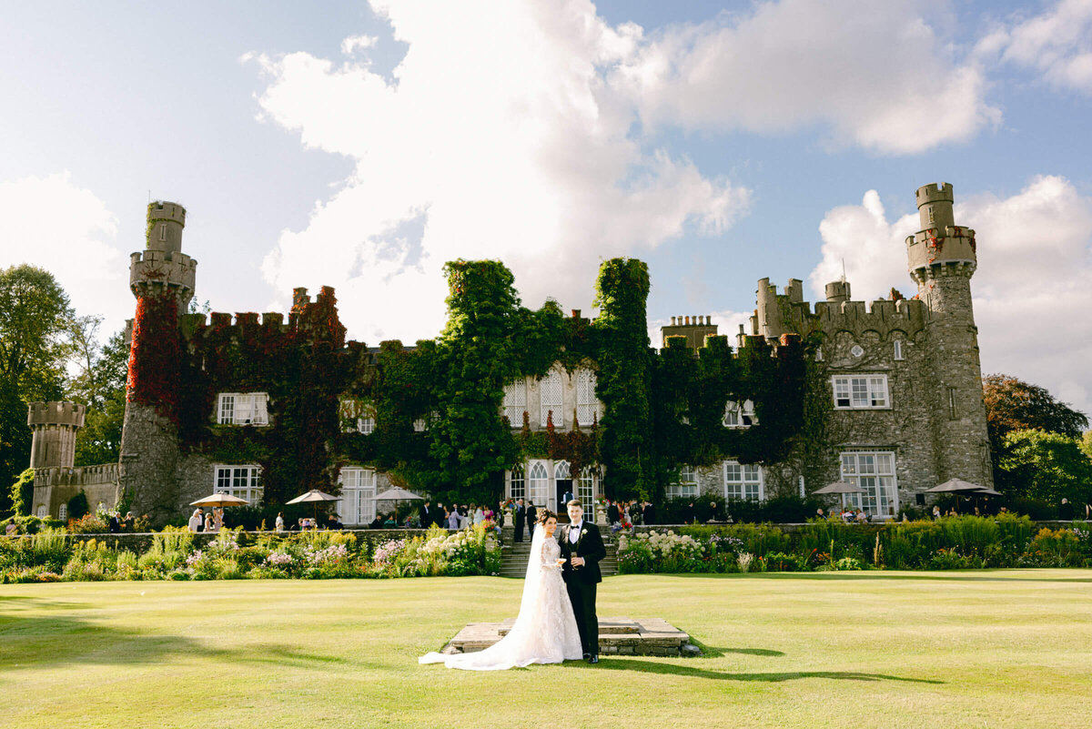 A wedding photo of the bride and groom together with Luttrellstown Castle behind them