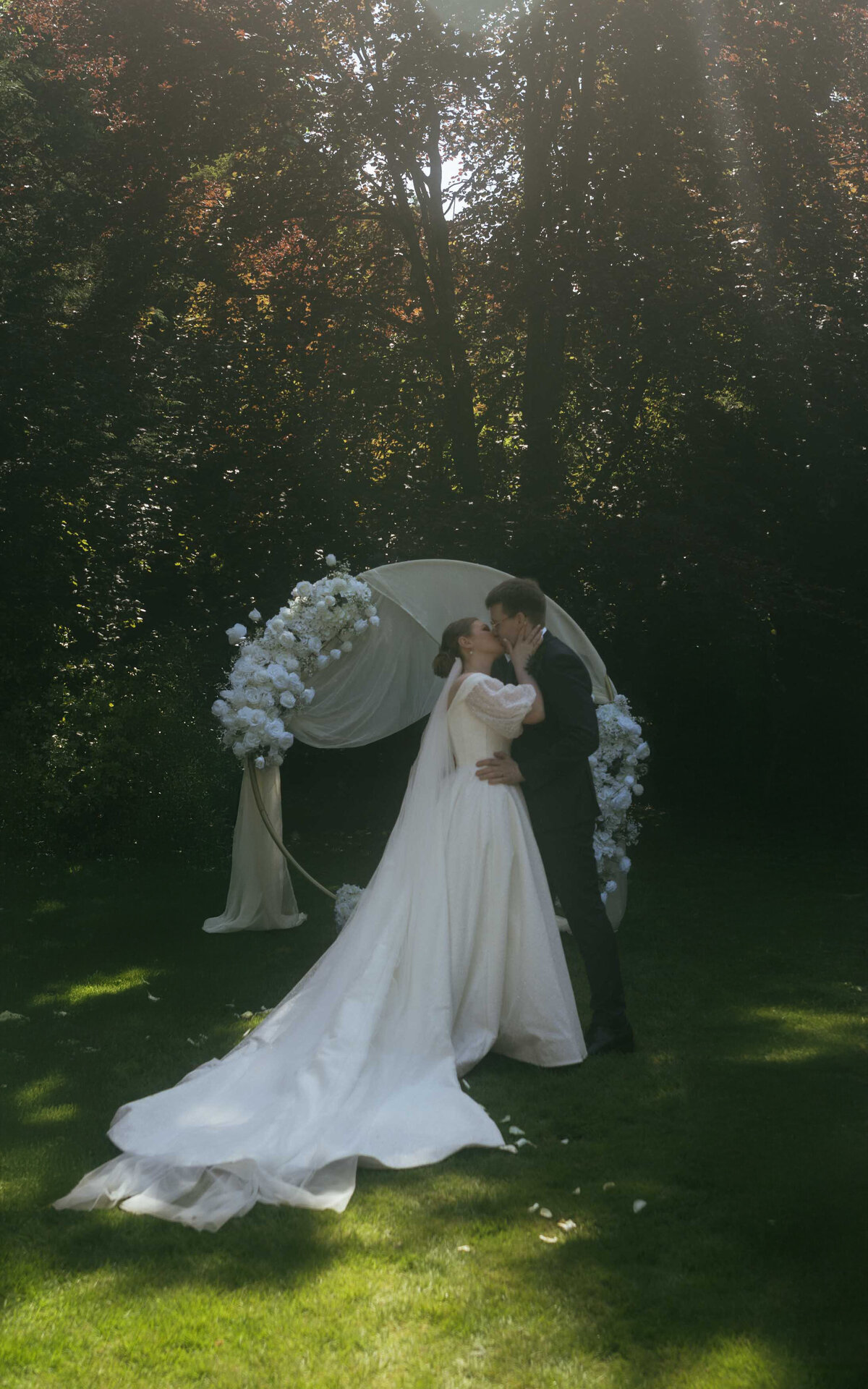 Capture the intimate and emotional moment of a couple sealing their vows with a kiss during their wedding ceremony
