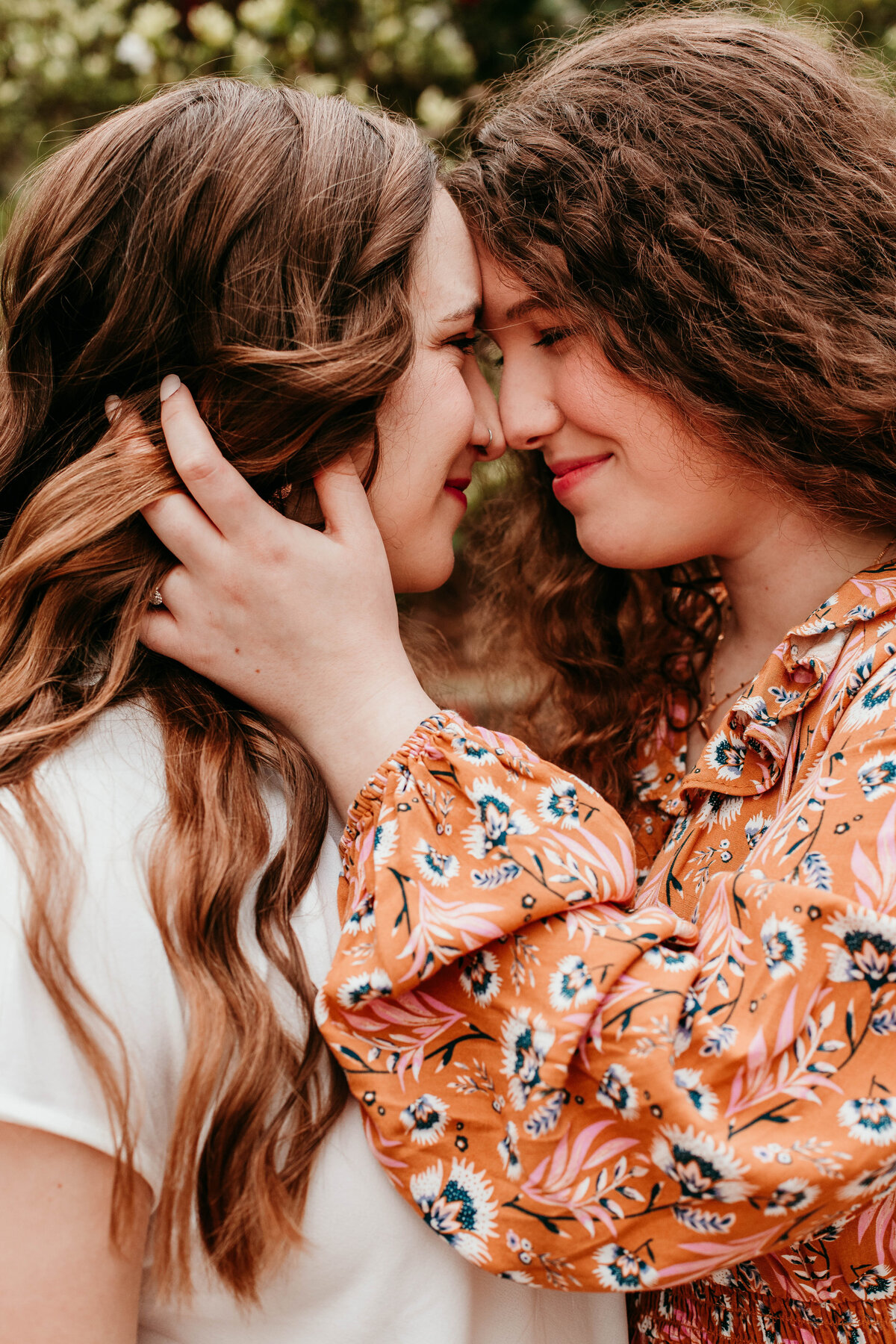 lesbian couple embraces during birmingham engagement session