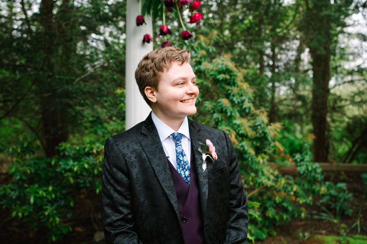 Bride in suit smiling down the wedding aisle