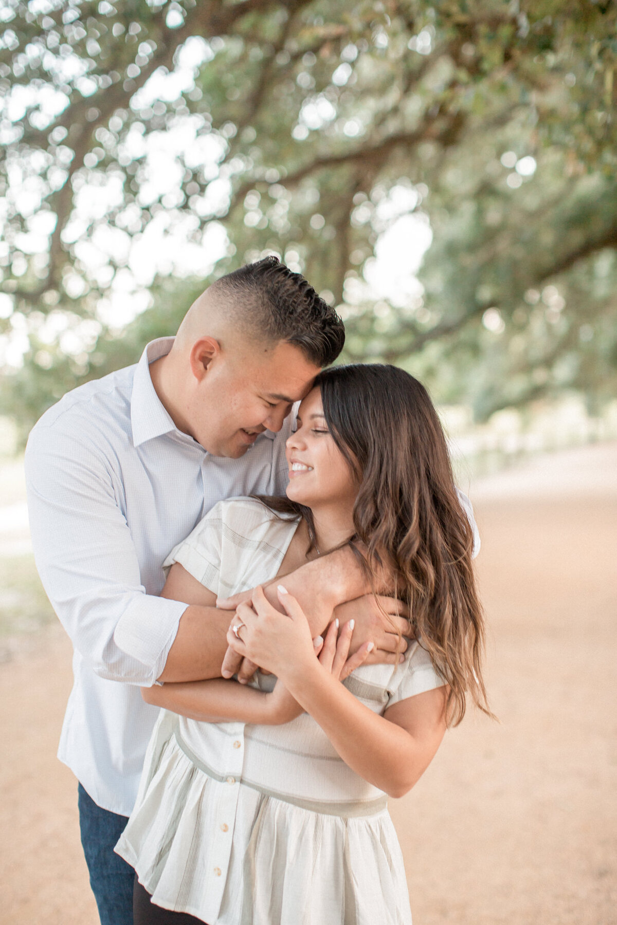 a man wraps up his fiancee in a warm embrace