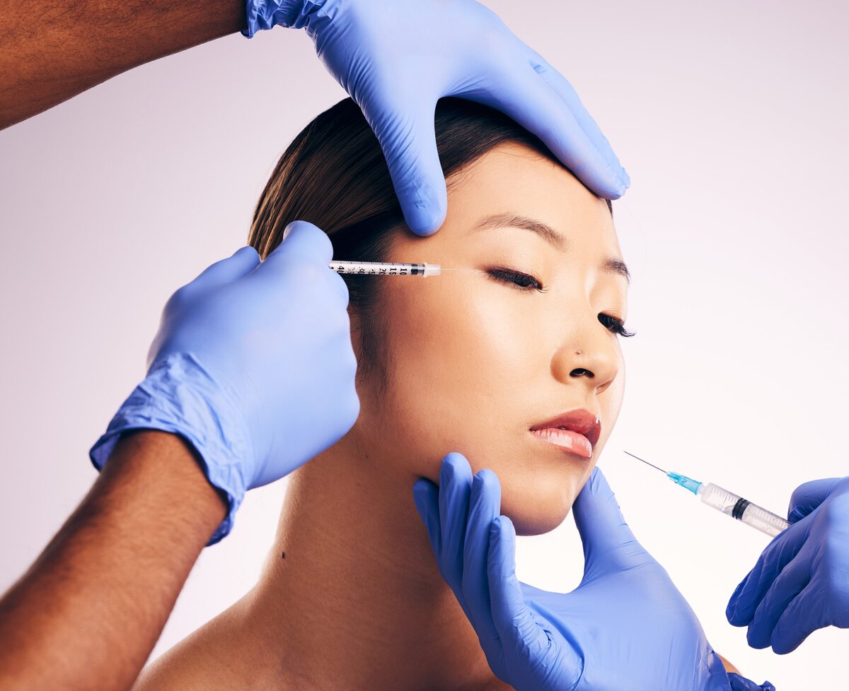woman-needle-and-hands-on-face-in-studio-for-surg-2023-11-27-04-54-20-utc