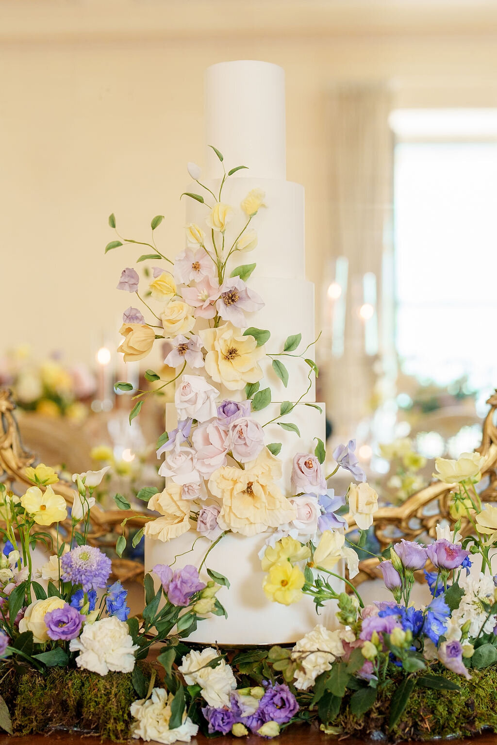 wedding cake sitting on a table surrounded by flowers