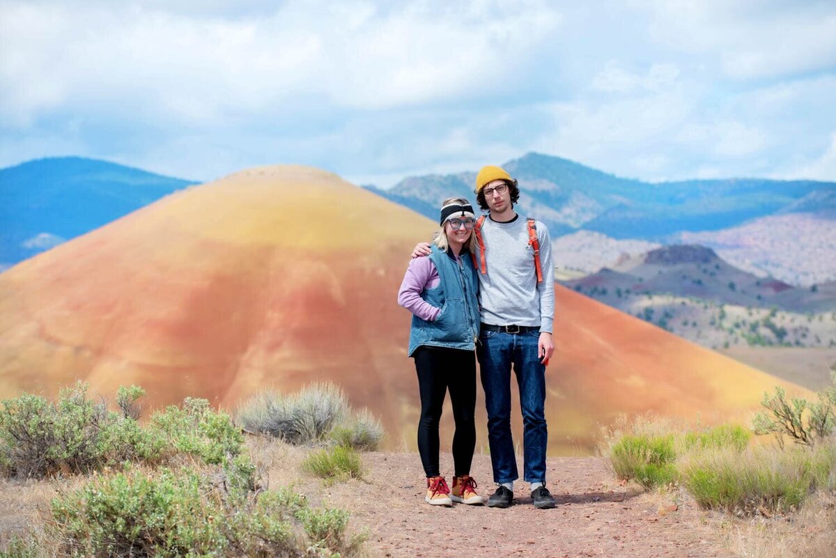 crystal genes stands with her boyfriend in front of the painted hills in oregon