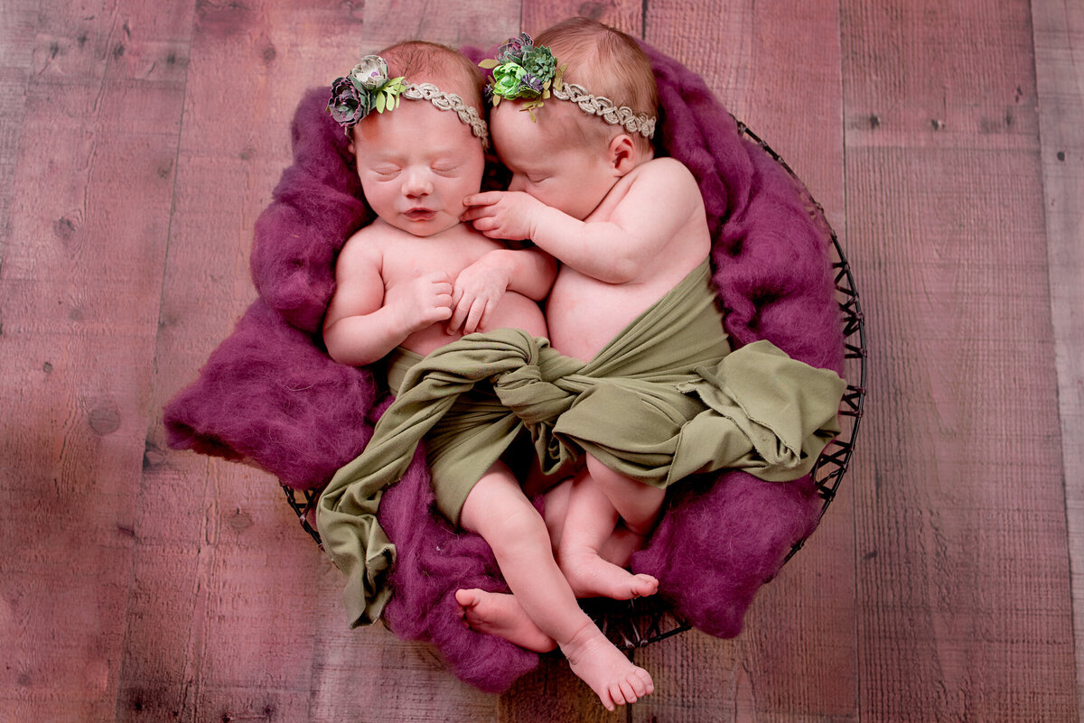 Newborn  twins wrapped snugly telling secrets, posed on a soft backdrop in Overland Park, Kansas. A timeless and cozy option for families seeking classic newborn photography.