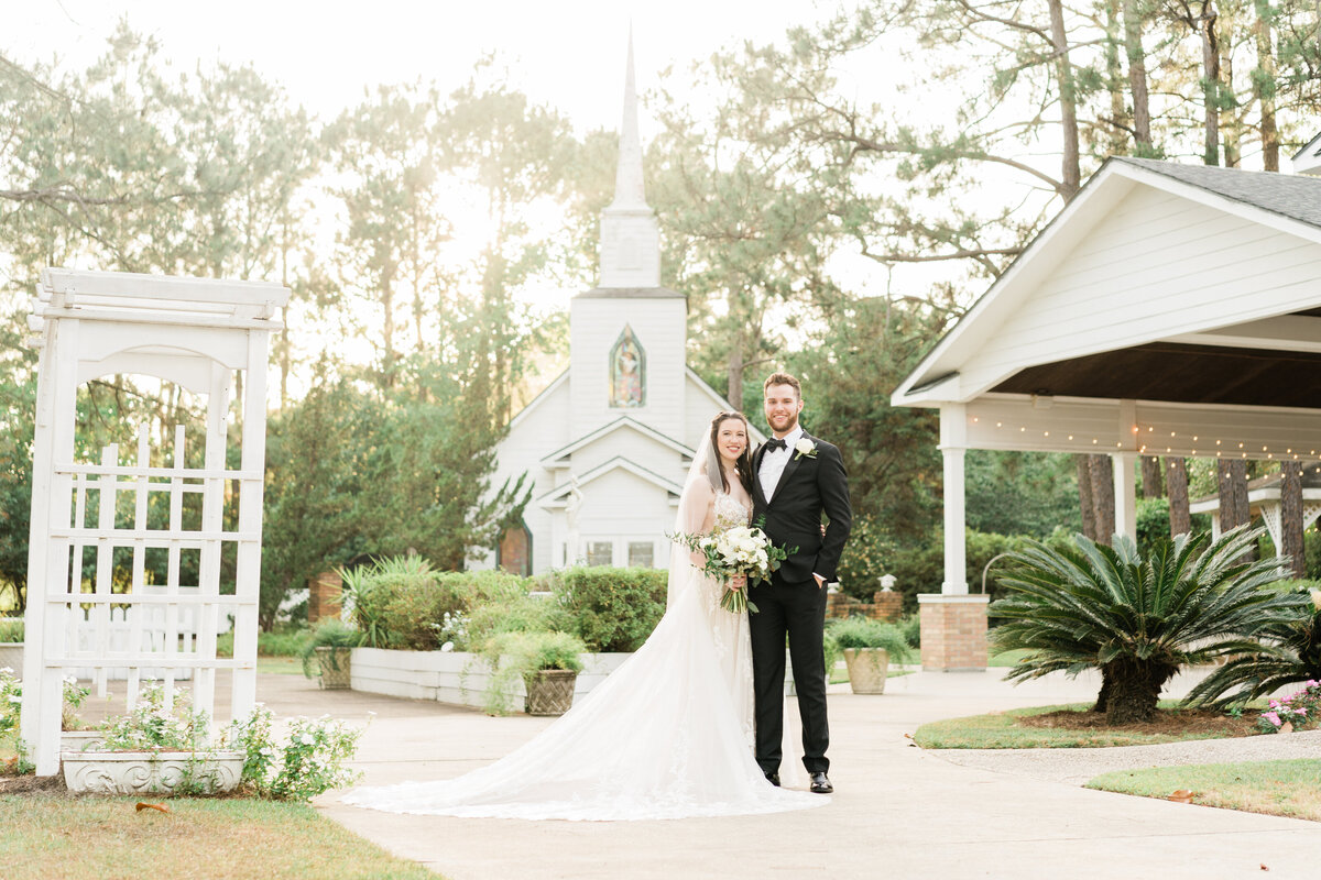Bride and groom in front of small white church in Alabama