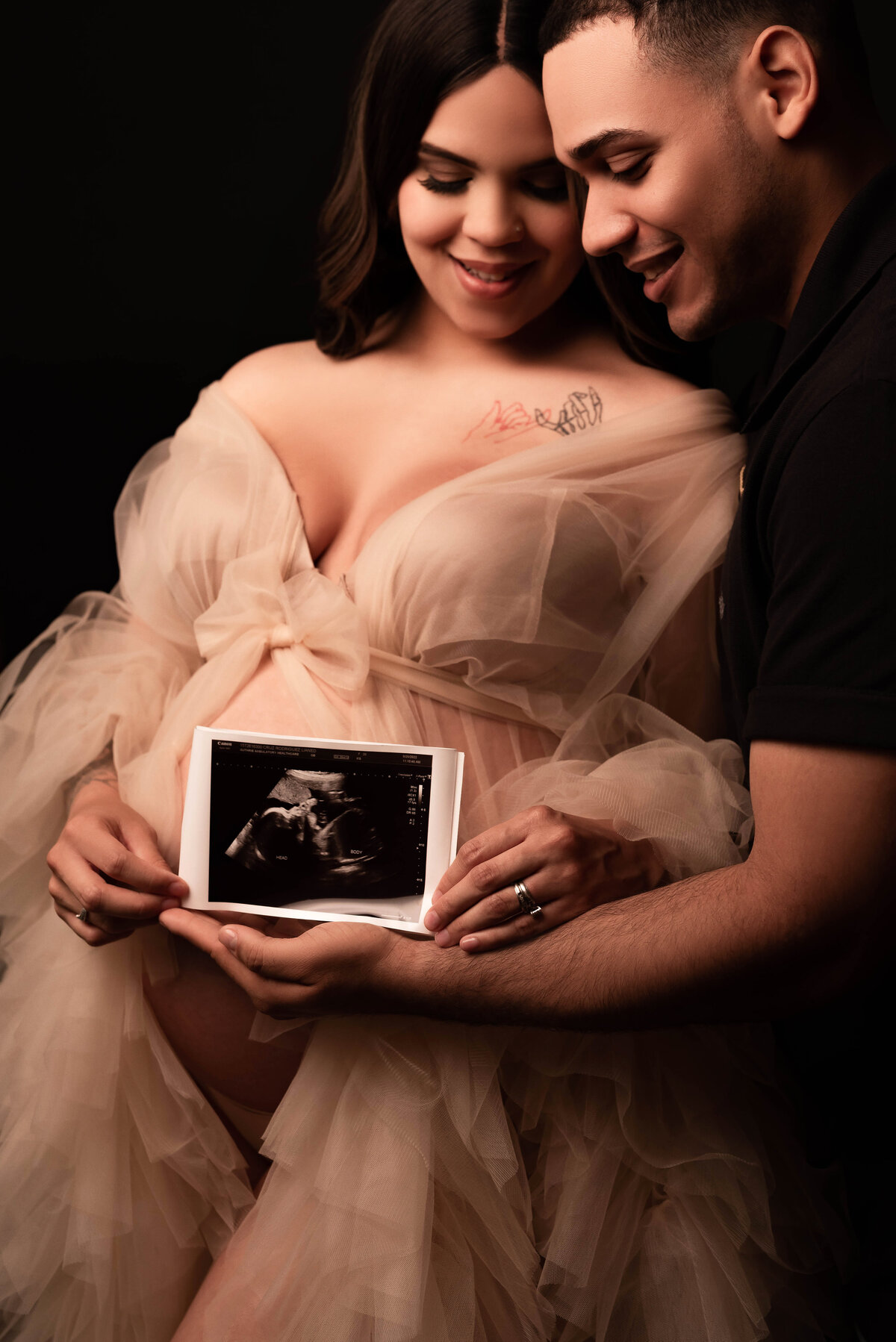 holding sono sonogram photo in hands at maternity session photoshoot in oswego
