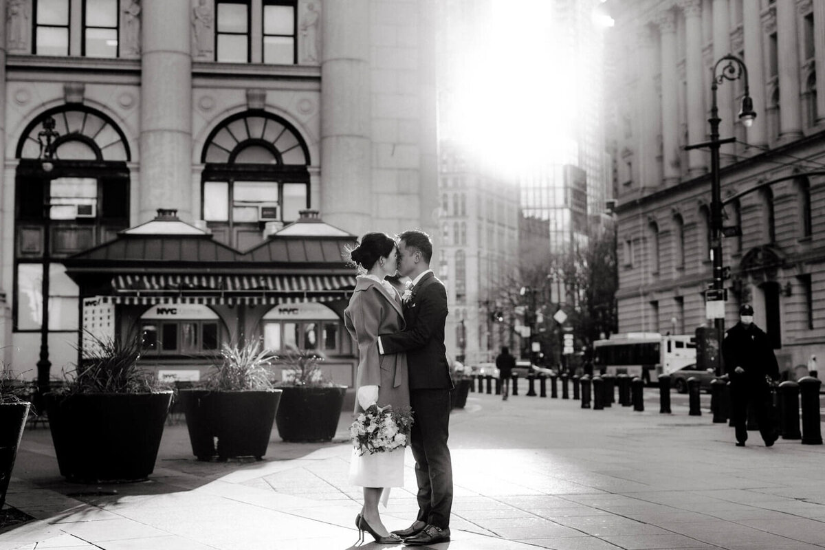 Black and white photo of the bride and groom kissing in the streets of New York City