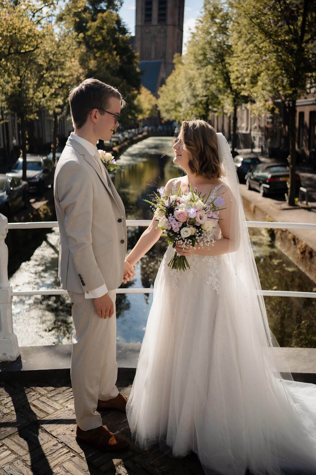 Getrouwd koppel op brug over gracht in Delft door trouwfotograaf Julia de Groot