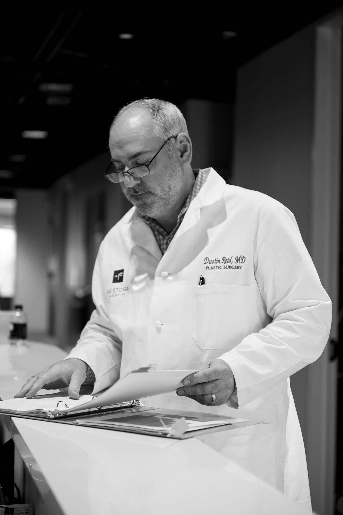 A professional image of a doctor in a clinic reading files