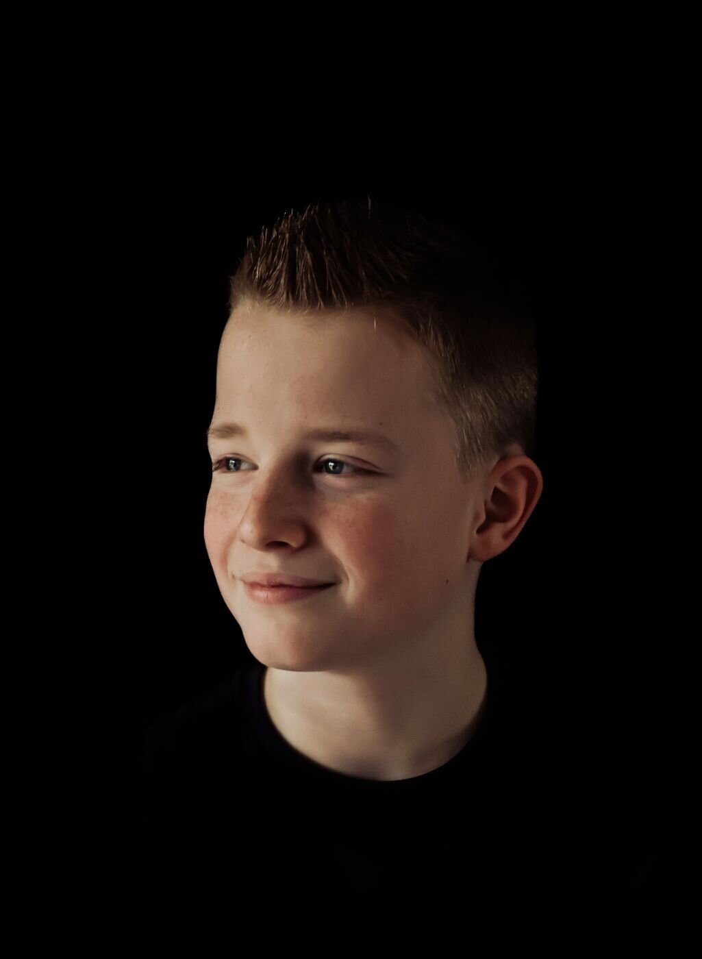 Een close-up portret van een vrolijke jongen met een heldere blik