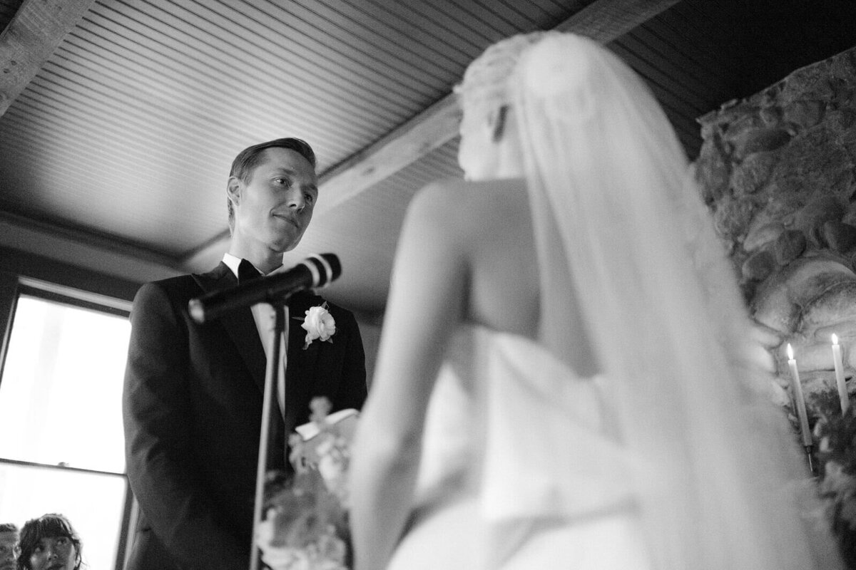 The bride and the groom say their vows in Foxfire Mountain House, New York. Wedding Image by Jenny Fu Studio
