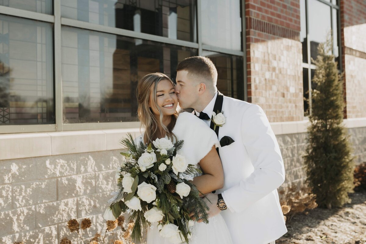 groom kissing brides cheek