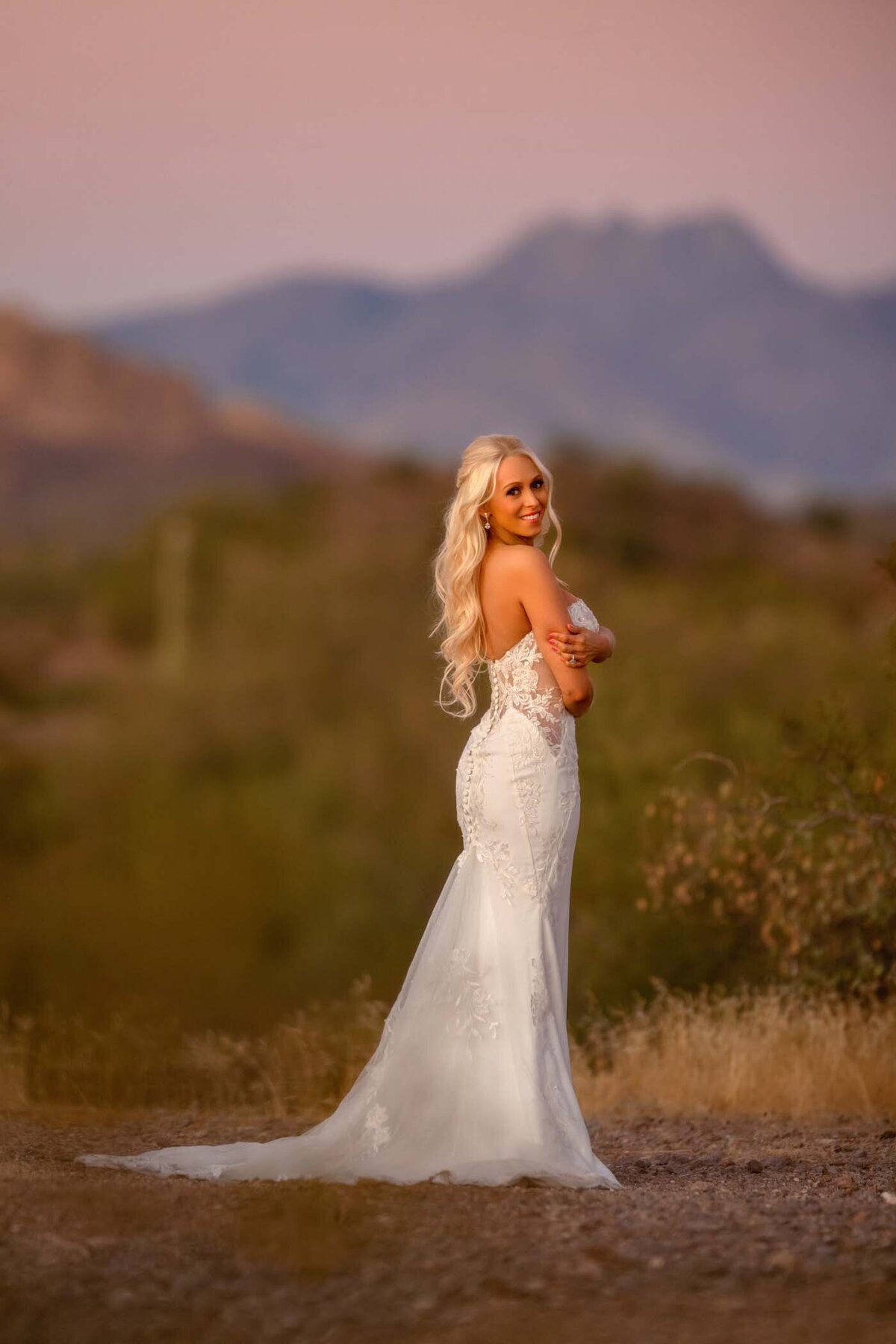 Long blond hair woman in white wedding dress at sunset at Lost Dutchman state park