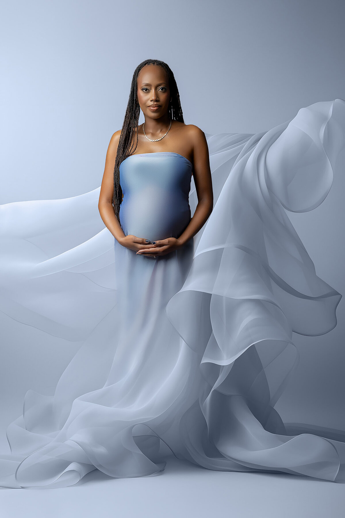stunning maternity photoshoot captures expecting mom wearing blue flowing gown, photo taken by White Orchid Photography - Maternity Photographer in Hamilton, ON