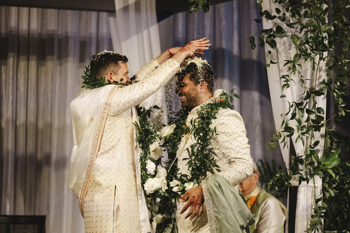 A person pouring rice over their partner's head at their wedding ceremony 
