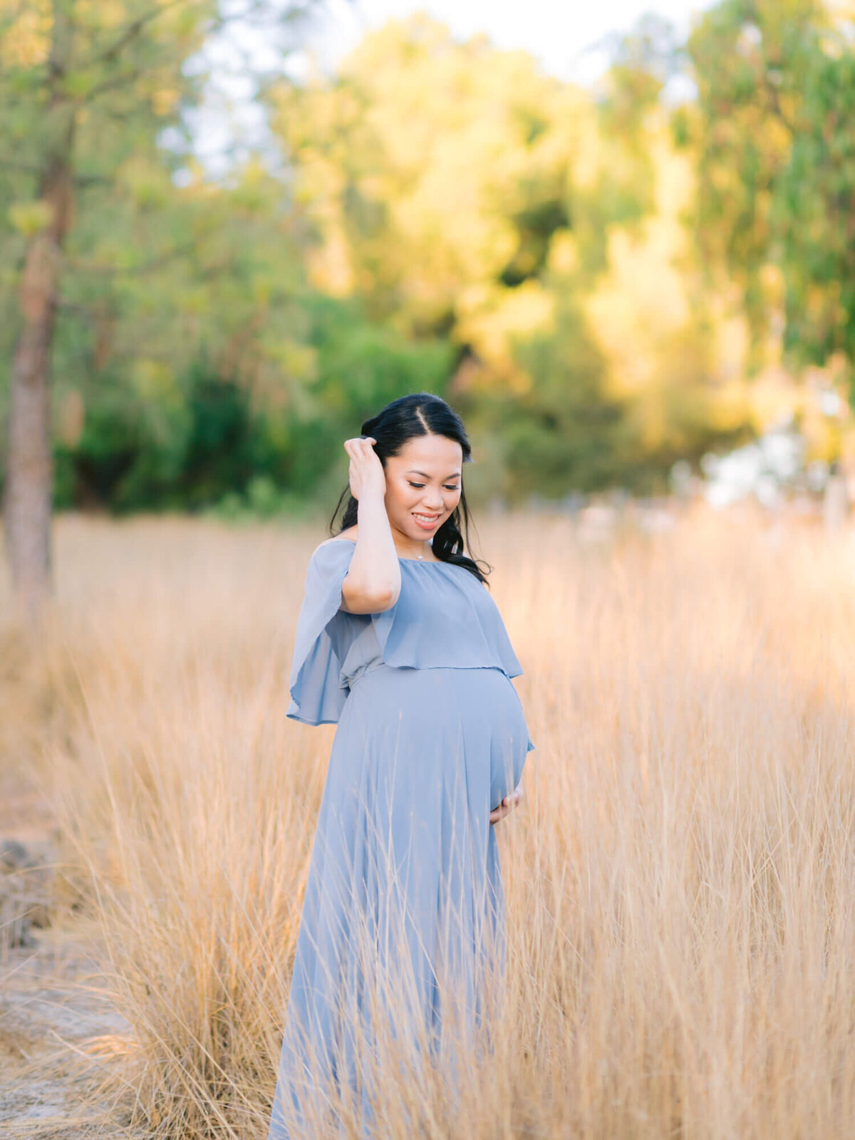 maternity portrait wearing blue flowy dress at yellow brown grass field in yorba linda