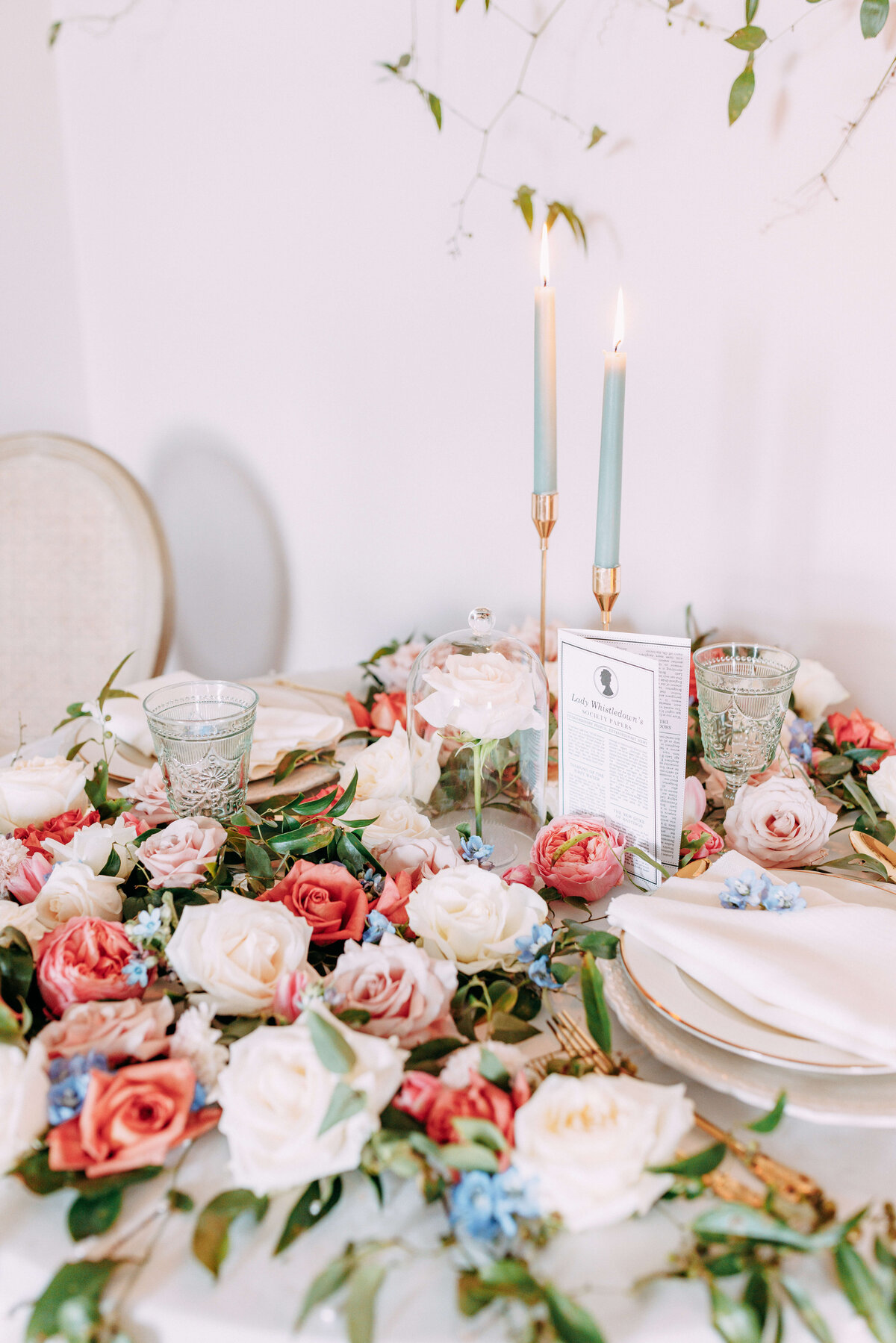 tablescape with florals, candles, plates and napkins