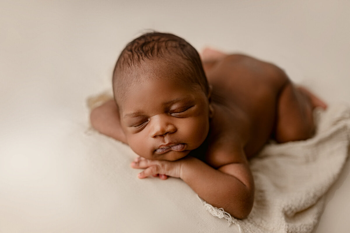 infant lying on cream blanket posed and captured by an atlanta newborn photographer