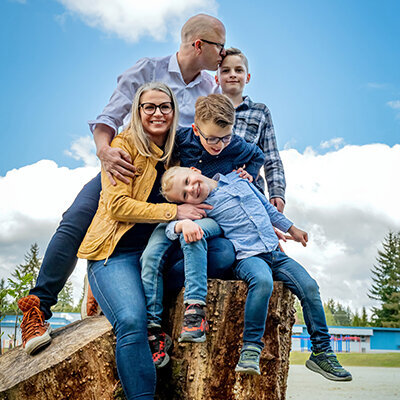 A family creates a moment of pure happiness while balancing on a tree stump in  Coquitlam