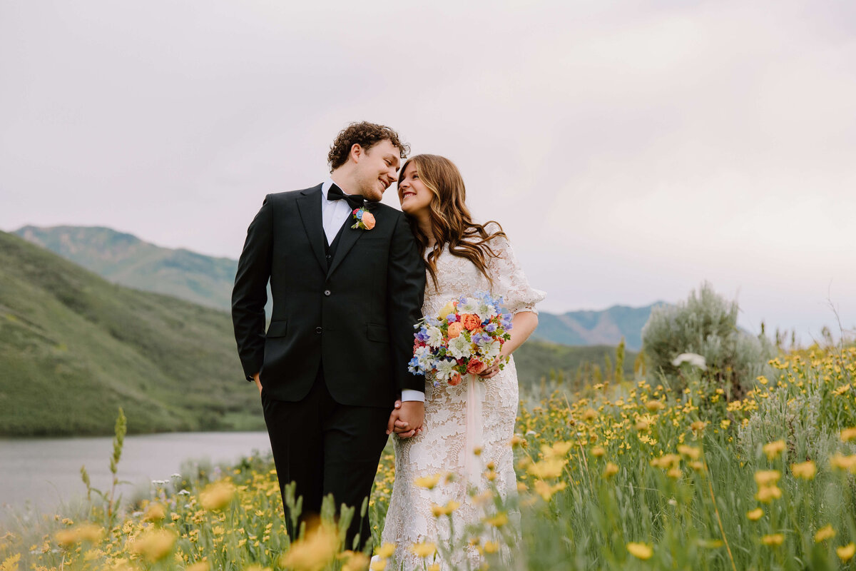 bride and groom standing in flower  field