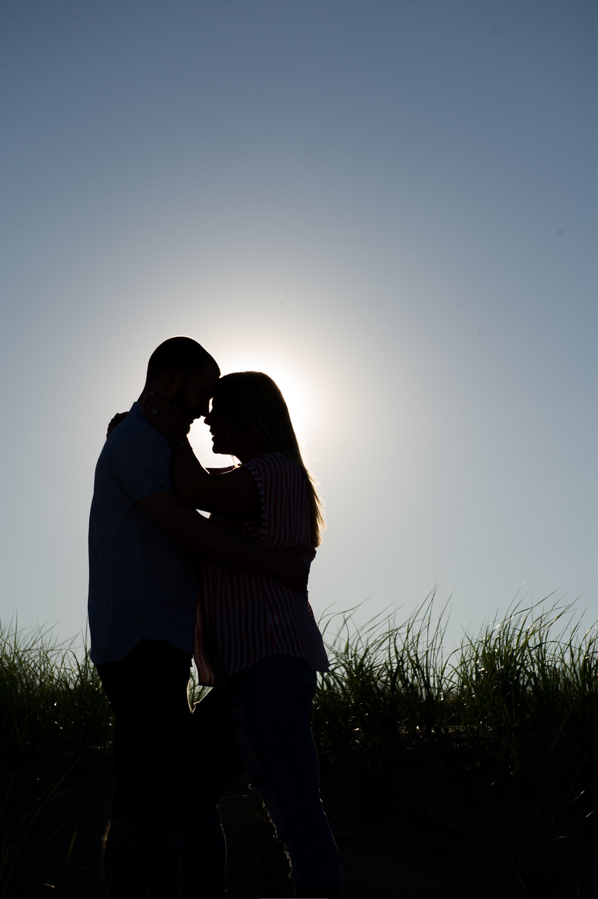 couple in dunes hug and smile