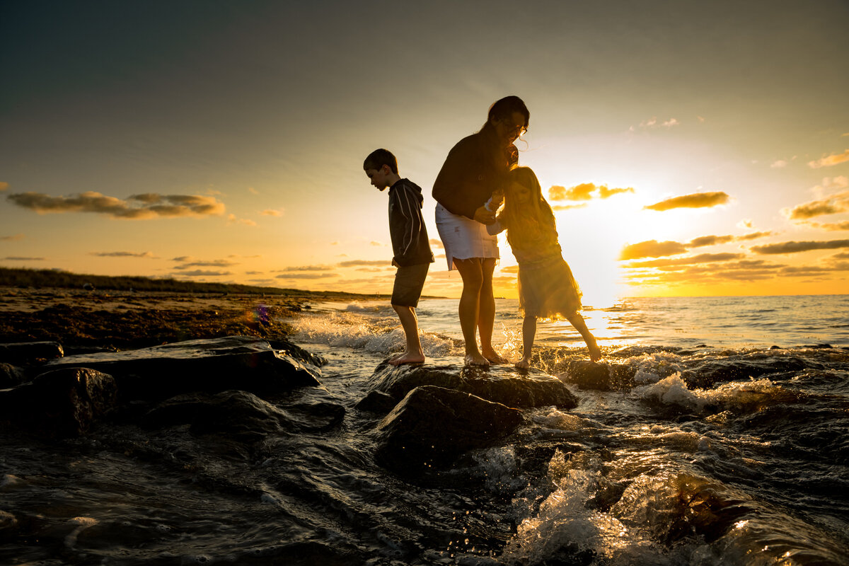 Mother helping her child at the beach during a family photography session