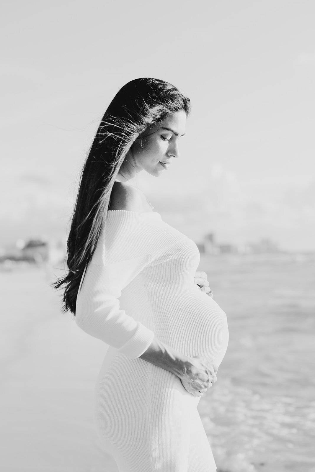 A profile portrait of an expectant mother with windblown hair, captured by Claudia Amalia Maternity Photography.