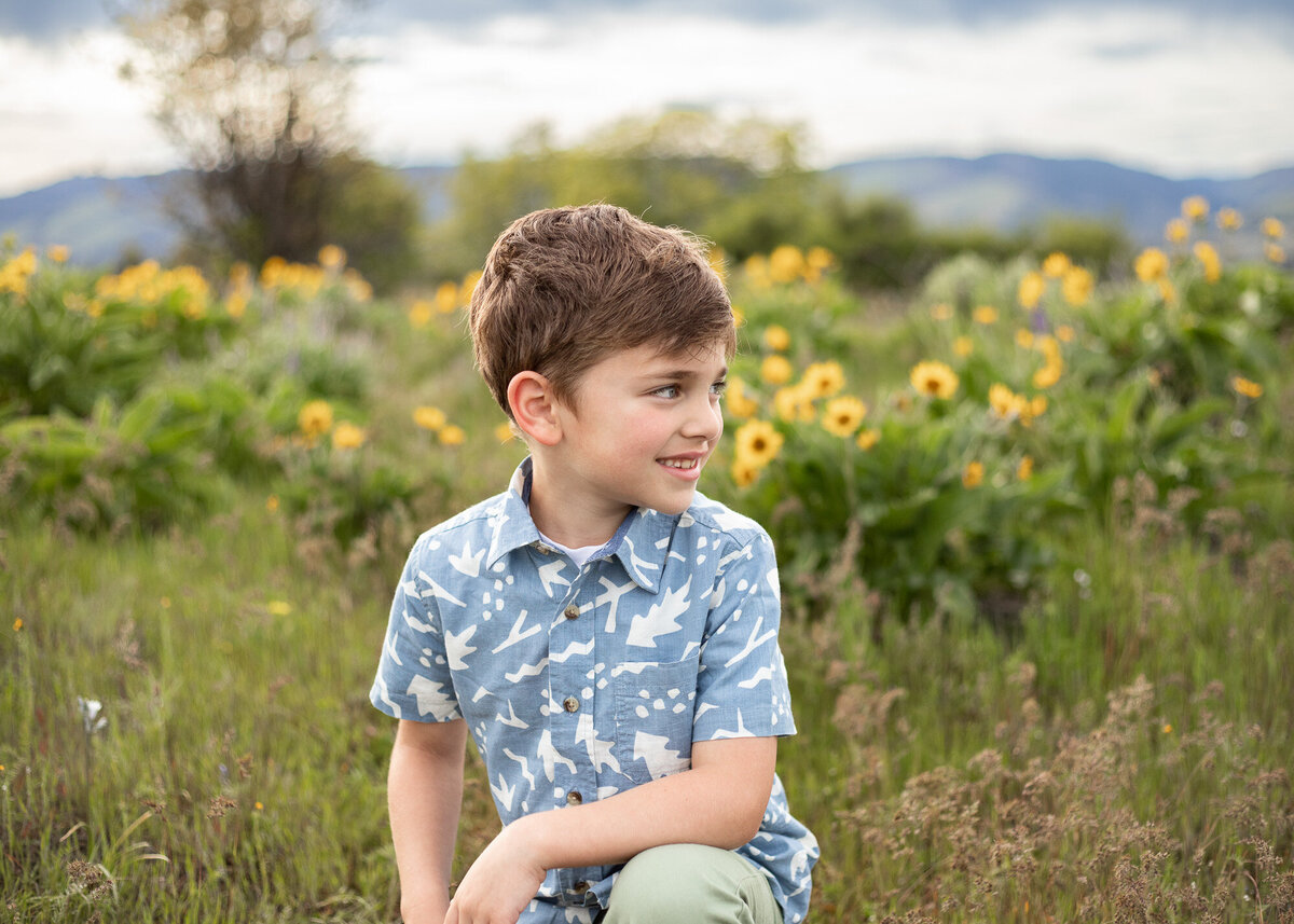 Young boy smiling in Oregon wildflower field.