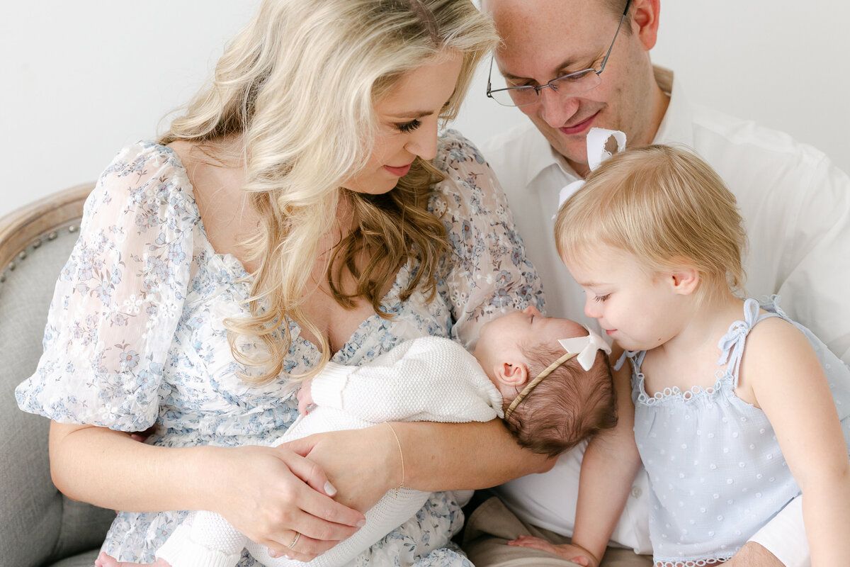 a family sitting with their newest child