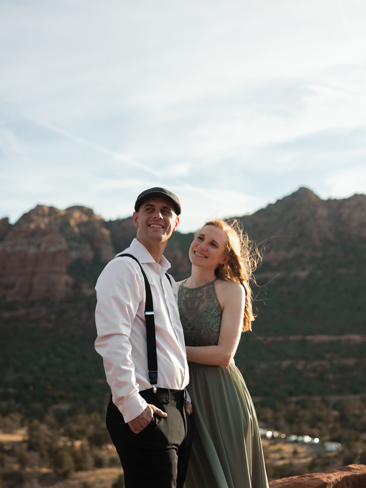 Couple standing against red rock backdrop during Sedona engagement session