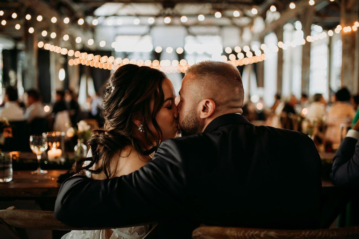 Bride and groom kissing during wedding reception at The Pipe Shop Venue, featured on the Brontë Bride Vendor Guide.
