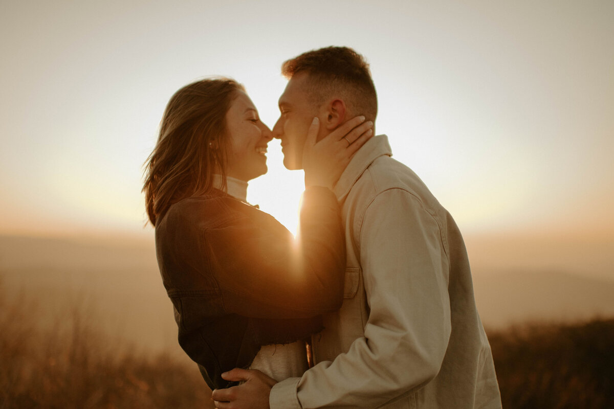 couple embraces during golden hour at reddish knob