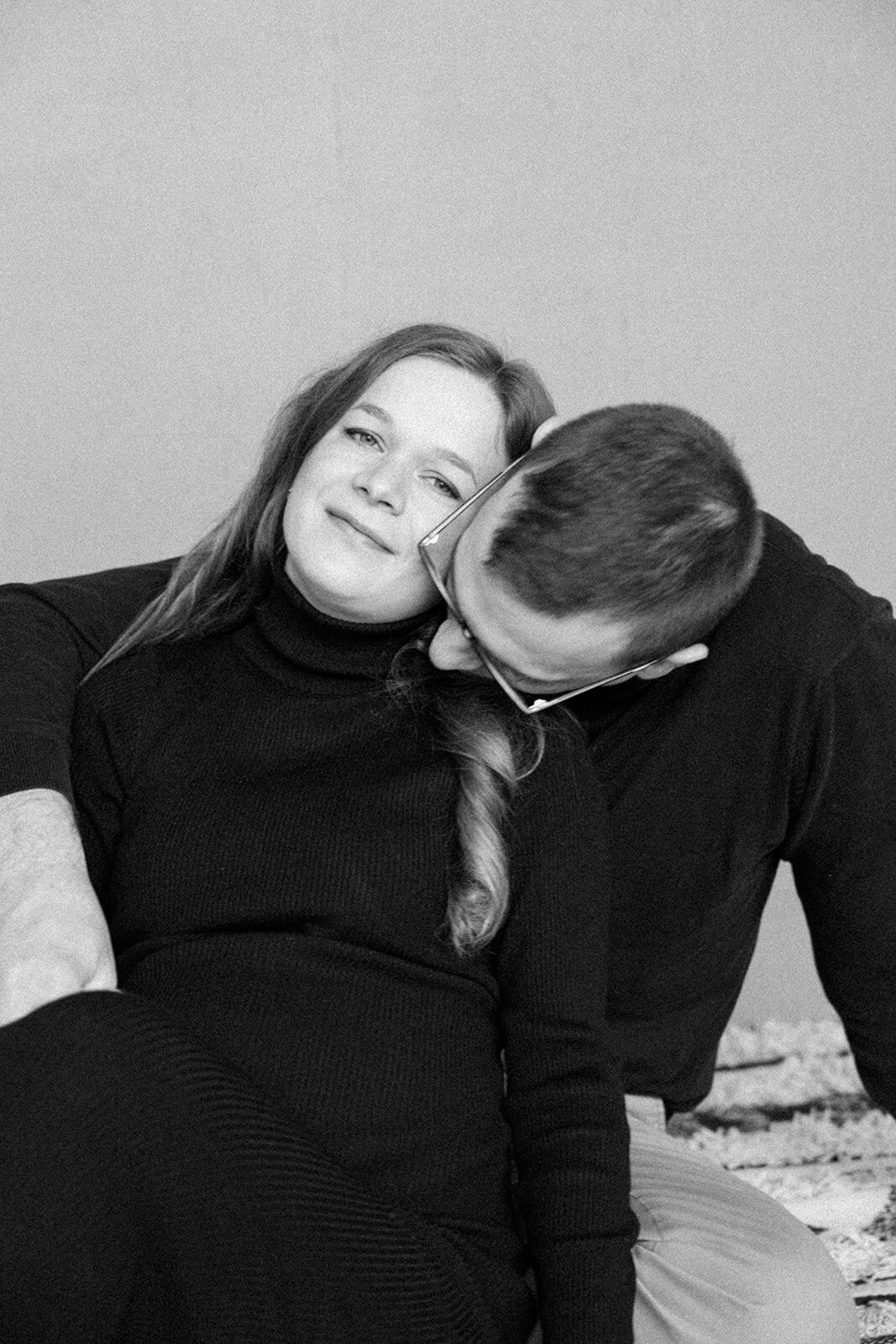 Husband kisses his wife's shoulder while casually enjoying each other. 