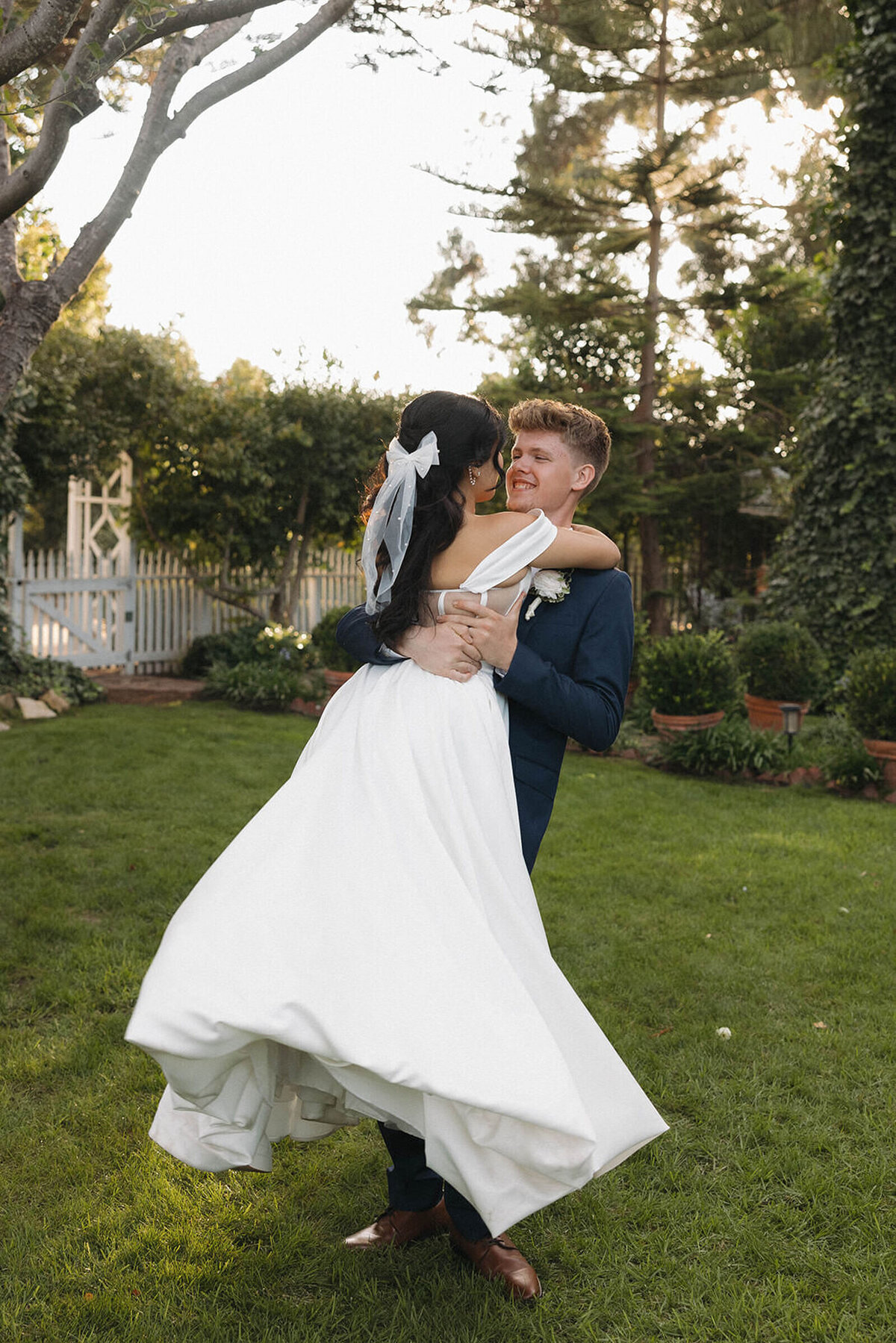 Groom spinning his bride in the garden