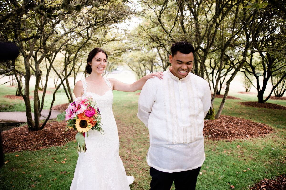 bride taps groom's shoulder in intimate wedding photo at uw botanical gardens