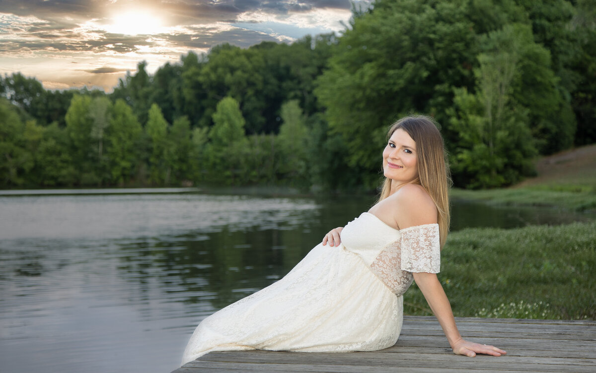 PREGCharlotte maternity photographer, maternity photography in Chalrotte NC, professional maternity photos near meNANT LADY SITTING BY THE LAKE IN A MATERNITY GOWN