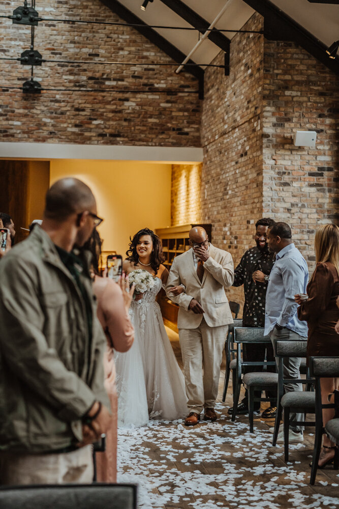 storyteller-collective-photo-co-bride-walking-down-aisle-with-father-surety-hotel-des-moines-iowa